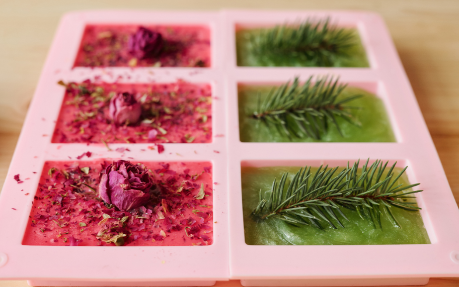 Assorted soap-making moulds, including silicone loaf moulds, wooden moulds, and plastic cavity moulds, displayed with vibrant handmade soaps and tools, inspired by professional soap-making essentials.