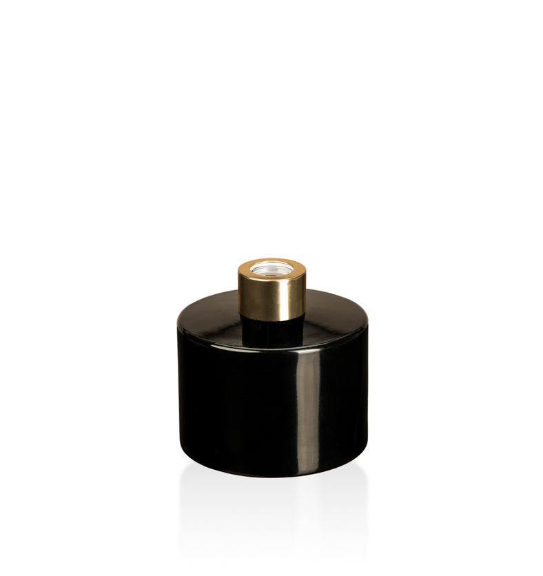 Image of a stout black glass diffuser bottle with a gold collar on a white background to represent Village Craft & Candle's Lavish Diffuser Bottle. || Image d'une bouteille de diffuseur en verre noire trapue avec un col doré sur un fond blanc pour représenter la bouteille de diffuseur Lavish de Village Craft & Candle.