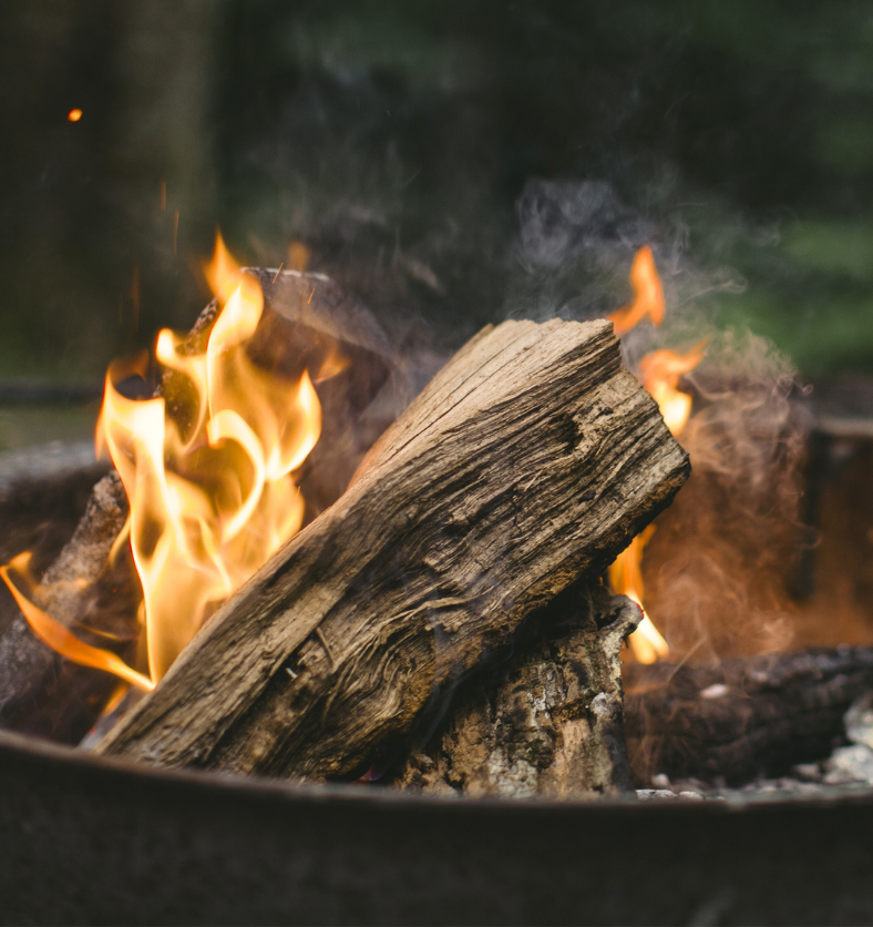 Wood burning fire in a firepit as a visual representation of Campfire Smoke Fragrance Oil available at Village Craft and Candle || Feu de bois dans un foyer comme représentation visuelle de l'huile parfumée de fumée de feu de camp disponible chez Village Craft and Candle