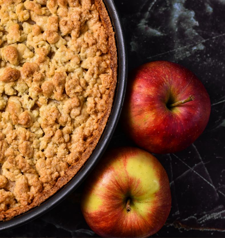 Apple crumble with 2 red apples as a visual representation of Dutch Apple Crumble Fragrance Oil available at Village Craft and Candle || Crumble aux pommes avec 2 pommes rouges comme représentation visuelle de l'huile parfumée Dutch Apple Crumble disponible chez Village Craft and Candle