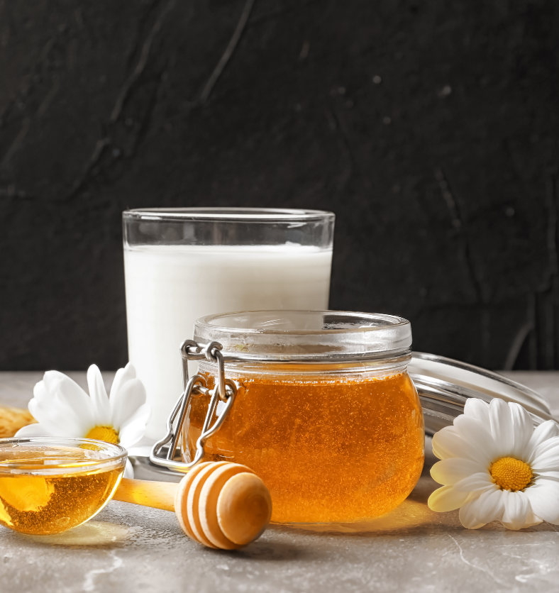 Honey & milk with flowers in the background as a visual representation of Milk & Honey Fragrance Oil available at Village Craft and Candle || Miel et lait avec des fleurs en arrière-plan comme représentation visuelle de l'huile parfumée Milk & Honey disponible chez Village Craft and Candle