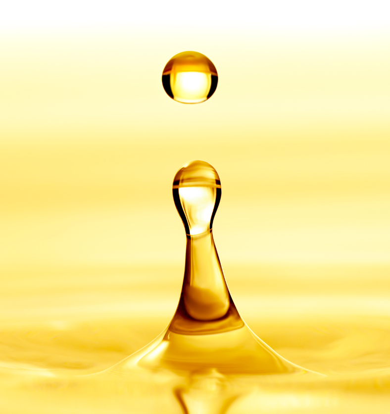 Golden drop of Polysorbate 20 above a splash of golden liquid. || Goutte dorée de Polysorbate 20 au-dessus d’une éclaboussure de liquide doré.
