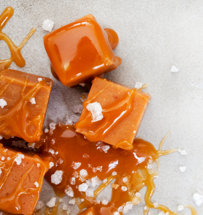 Plates of caramel squares with coarse salt as garnish as a visual representation of Salted Caramel Fragrance Oil available at Village Craft and Candle || Assiettes de carrés de caramel avec du gros sel comme garniture comme représentation visuelle de l'huile parfumée au caramel salé disponible chez Village Craft and Candle