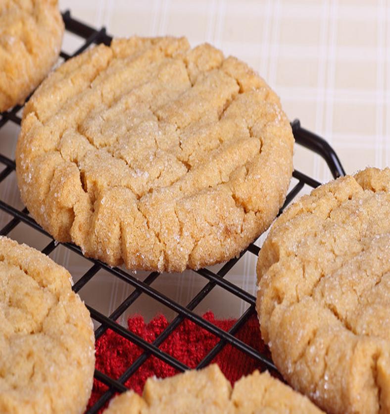 Close up of sugar cookies cooling on a black wire rack as a visual representation of Sugar Cookie (Village) Fragrance Oil available at Village Craft and Candle || Gros plan de biscuits au sucre refroidissant sur une grille noire comme représentation visuelle de l'huile parfumée Sugar Cookie (Village) disponible chez Village Craft and Candle