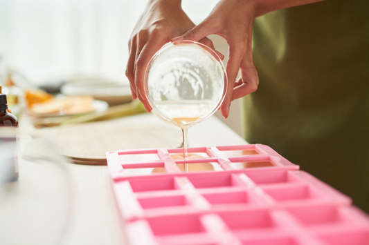 Pouring melt and pour soap base into silicone molds for handmade soap making