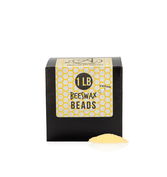  Gros plan d'une boîte noire avec une étiquette indiquant 1LB Yellow Beeswax Beads pour représenter les pastilles de cire d'abeille jaune de Village Craft & Candles.