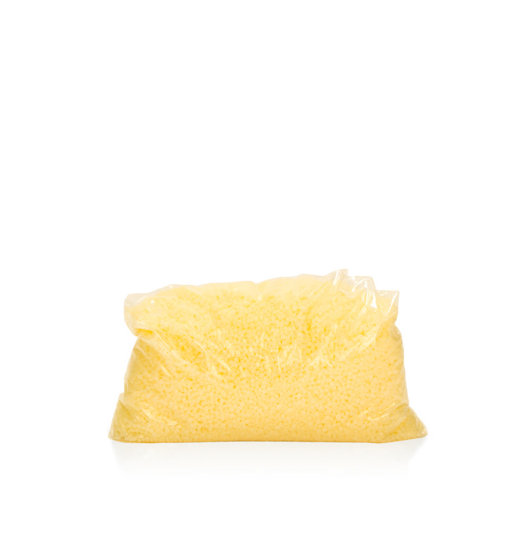 Image of yellow beads of wax in a clear bag to represent Village Craft & Candles Yellow Beeswax Pastilles || Image de perles de cire jaune dans un sac transparent pour représenter les pastilles de cire d'abeille jaune de Village Craft & Candles.