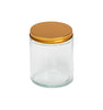 Image of a clear glass jar with a low profile gold lid to represent Village Craft & Candle's 8oz Clear Flint Element Straight Side Jar & Classic Gold Element Lid for candle making || Image d'un pot en verre transparent avec un couvercle doré à profil bas représentant le pot droit Element Flint clair de 8 oz et le couvercle doré classique Element de Village Craft & Candle pour la fabrication de bougies.