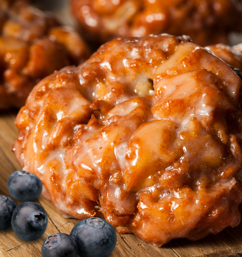 Blueberry Fritter on a black cookie sheet as a visual representation of Blueberry Fritter Fragrance Oil available at Village Craft and Candle || Beignets de bleuets sur une plaque à biscuits noire comme représentation visuelle de l'huile parfumée de beignets de bleuets disponible chez Village Craft and Candle