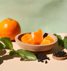  Image of a peeled mandarin orange in a bowl with black pepper & mint sprigs to represent the Village Craft & Candle Apollo Fragrance Oil | Image d'une mandarine épluchée dans un bol avec du poivre noir et des brins de menthe pour représenter l'huile de parfum Apollo de Village Craft & Candle