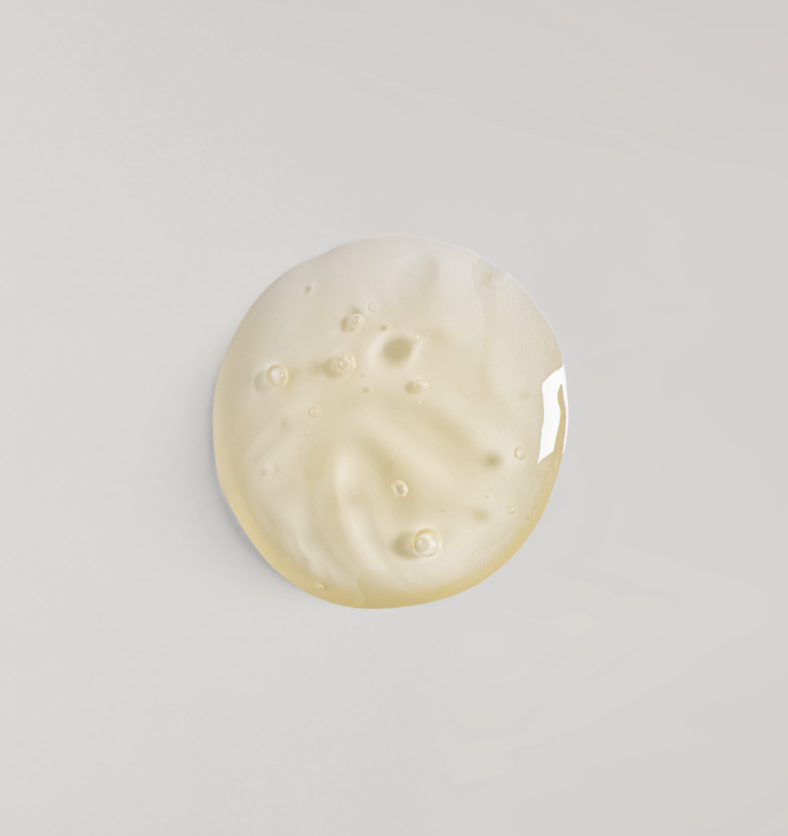 Light yellow liquid drop of body wash base with small bubbles. || Goutte de base de gel douche jaune pâle avec de petites bulles.