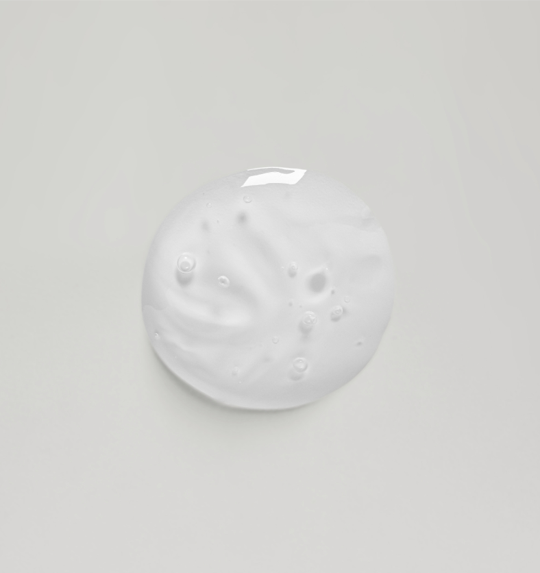Clear drop of liquid soap base on a white background. || Goutte claire de base de savon liquide sur un fond blanc.