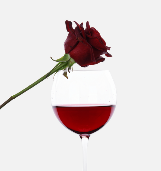  Verre de vin rouge avec une rose posée dessus comme représentation visuelle de l'huile parfumée de vin rouge et de roses disponible chez Village Craft and Candle