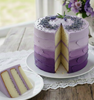 An image of a vanilla layer cake with textured purple ombre buttercream frosting & dried lavender buds. This image represents the Vanilla Lavender Buttercream fragrance oil, highlighting notes of sweet cream and floral lavender. || Une image d'un gâteau à étages à la vanille avec un glaçage à la crème au beurre texturé en dégradé de violet et des boutons de lavande séchés. Cette image représente l'huile parfumée Crème au beurre vanille et lavande, mettant en valeur des notes de crème sucrée et de lavande.