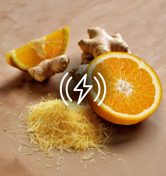 Oranges and ginger with grated ginger in the foreground with a lightning bolt graphic  as a visual representation of Orange Zest & Ginger EmotiScents (Energy) Fragrance Oil available at Village Craft and Candle 