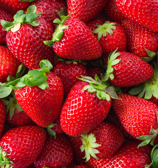  Fraises brillantes sur table en bois comme représentation visuelle de l'huile parfumée à la fraise disponible chez Village Craft and Candle