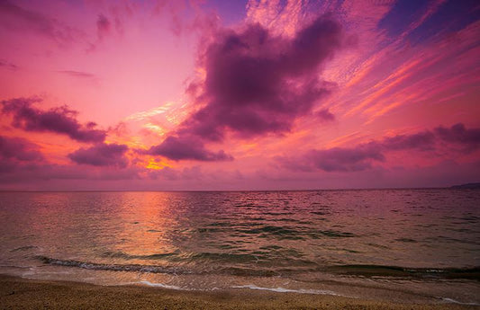  Coucher de soleil rose et violet sur une plage verte de l'océan comme représentation visuelle de l'huile parfumée Sunset Mirage disponible chez Village Craft and Candle
