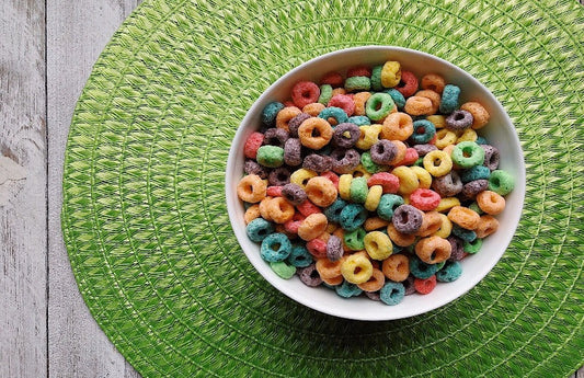Bowl of multi-coloured, round shaped cereal as a visual representation of Fruit Loops Fragrance Oil available at Village Craft and Candle 