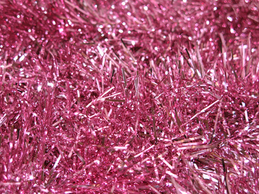 Ultra close up of a bed of shiny pink tinsel as a visual representation of Pink Tinsel Fragrance Oil available at Village Craft and Candle 