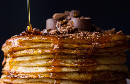 Stack of crepes and pancakes drizzled in honey and chocolate as a visual representation of Maple Syrup & Hazelnut Fragrance Oil available at Village Craft and Candle 