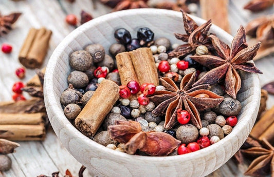  Bol en bois avec des épices d'automne et des noix comme représentation visuelle de l'huile parfumée Harvest Jubilee disponible chez Village Craft and Candle